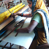 

   A weaver creating the fabric on a handloom   
.
